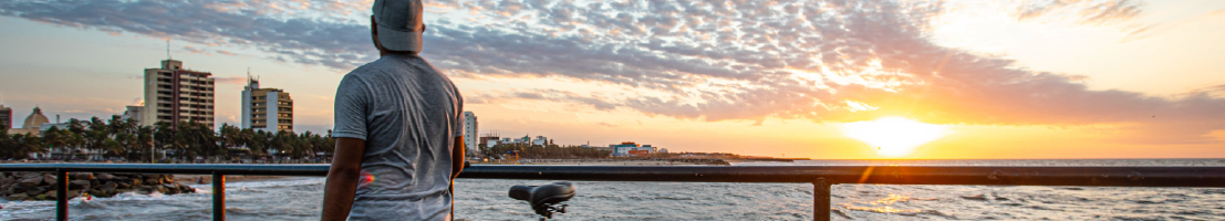 Hombre con bicicleta viendo hacia el horizonte